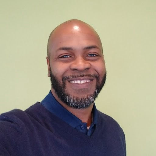 Chaka Ali, experienced life insurance consultant and founder of A.L.I. Creative Solutions | Wealth Builders Insurance Agency, smiling in a professional headshot.